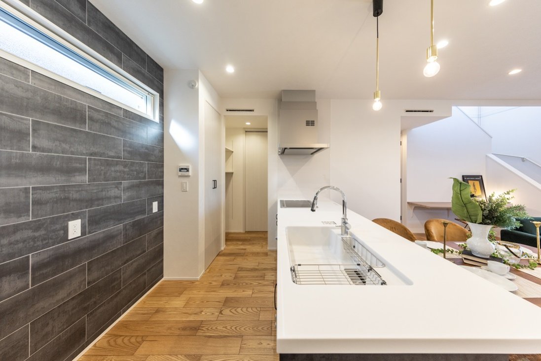 キッチン背面に施した壁一面のデザインタイルの存在感が◎