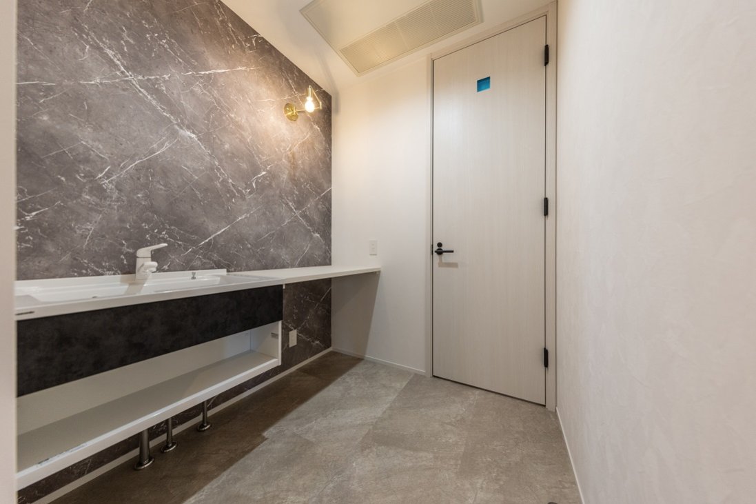 フロートタイプのカウンターとマーブルな壁がホテルライクな洗面