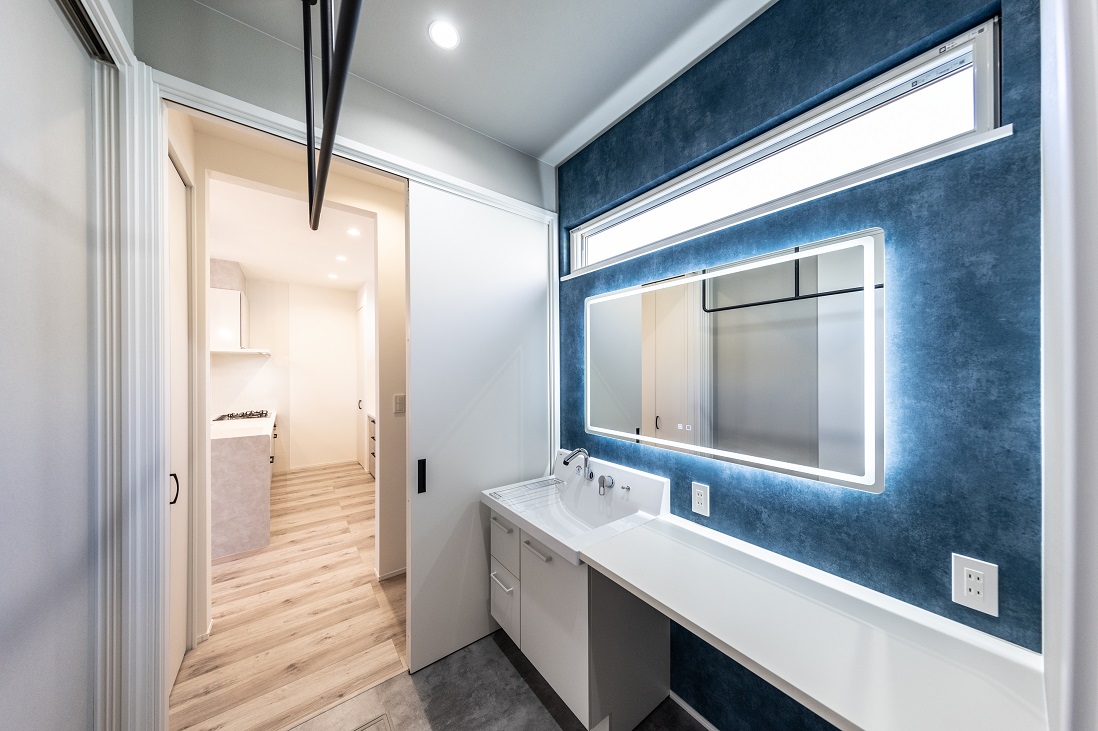  穏やかな海を感じさせるブルーを採用したロングカウンターの洗面