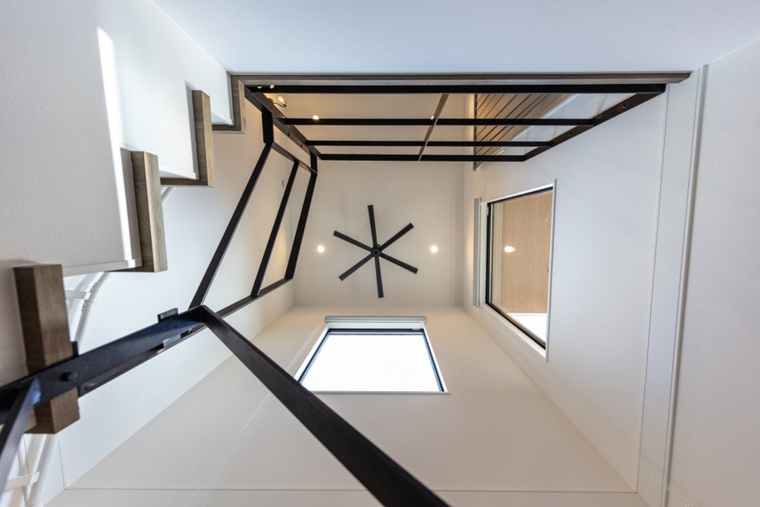 シーリングファンとアイアン手摺りとサッシのブラックが効いた吹抜け