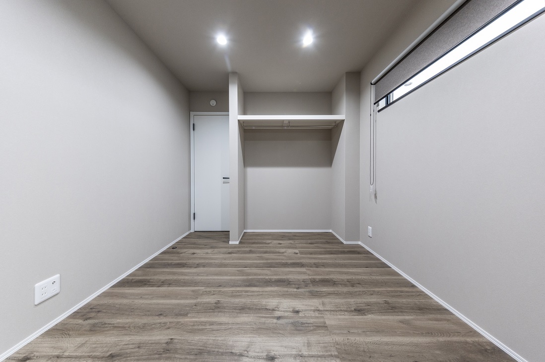 床・壁・扉をグレイッシュなトーンでまとめた落ち着ける寝室