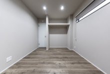 床・壁・扉をグレイッシュなトーンでまとめた落ち着ける寝室