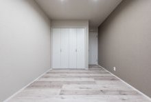 床・壁・扉をグレイッシュなトーンでまとめた落ち着ける寝室