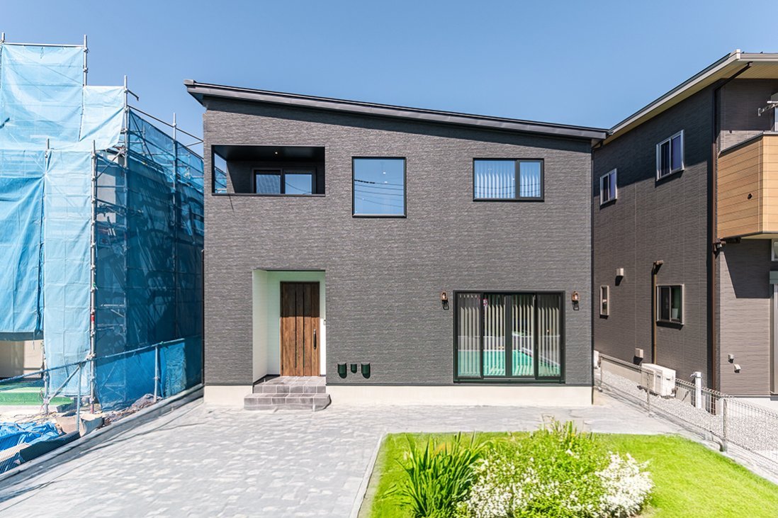 玄関ドアのセットバックを白いアクセントでモダンな印象を高めた外観