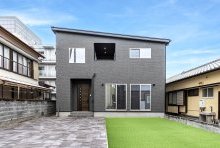 細く石積みされた印象の外壁に木目のアクセントが温かみを感じる外観