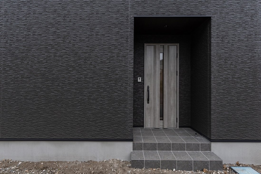 チャコールブラックの外壁にグレイッシュなドアがシックなエントランス