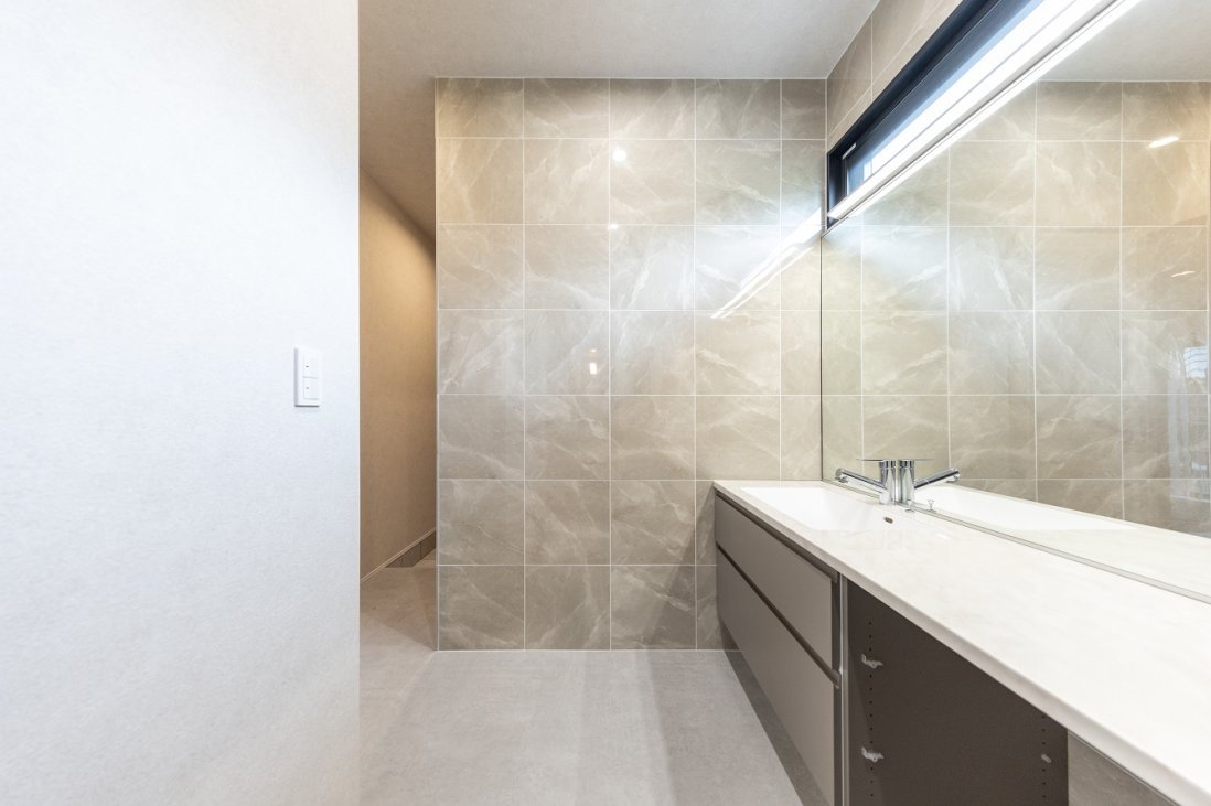 グレージュの大判タイルを２面に使用したラグジュアリーな洗面