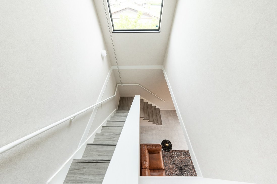 大きな窓を設けた明るい吹抜け階段には、心地よい光が漂う