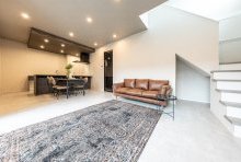 モルタル調の床に全面ガラスのリビングドアがシックなLDK