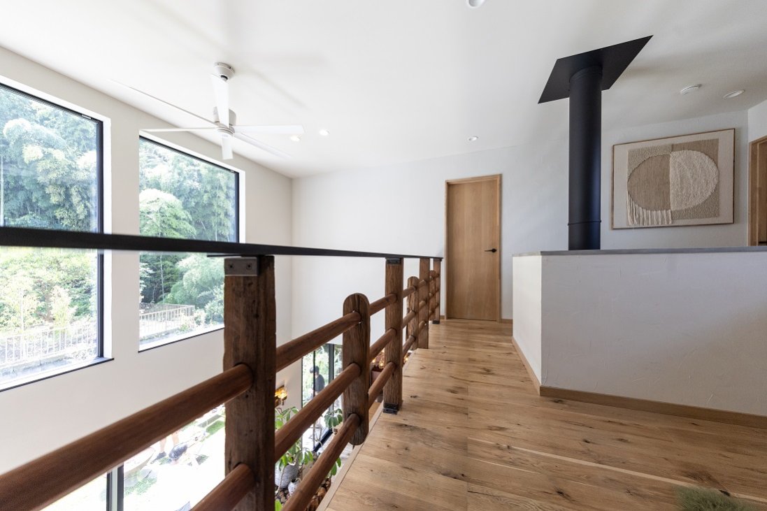 アンティークのシェルフを丁寧に解体し、吹抜けに面する手摺りに再構築