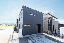 品位あるダークネイビーの外壁が端正なキューブリックな外観を引き立てる