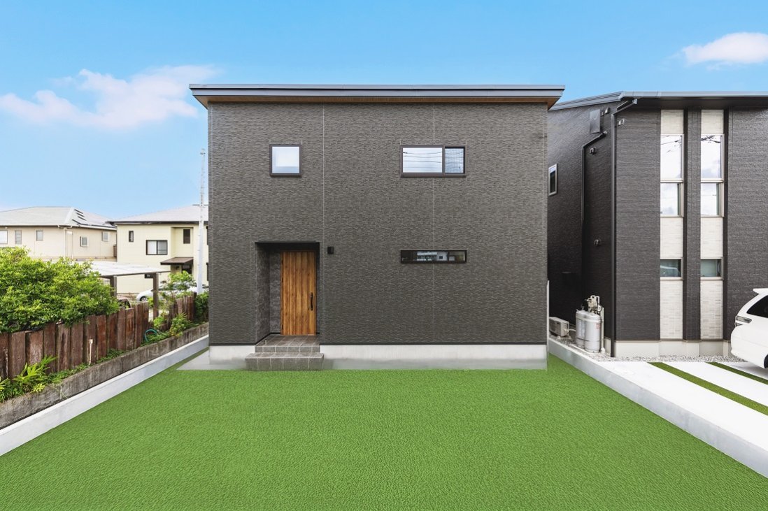 シックな印象を与えるブラックの外観にマキアートパインの扉が印象的