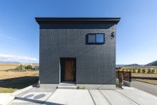 整然とした目地と表面の繊細な表情が品のあるネイビーを演出する外観