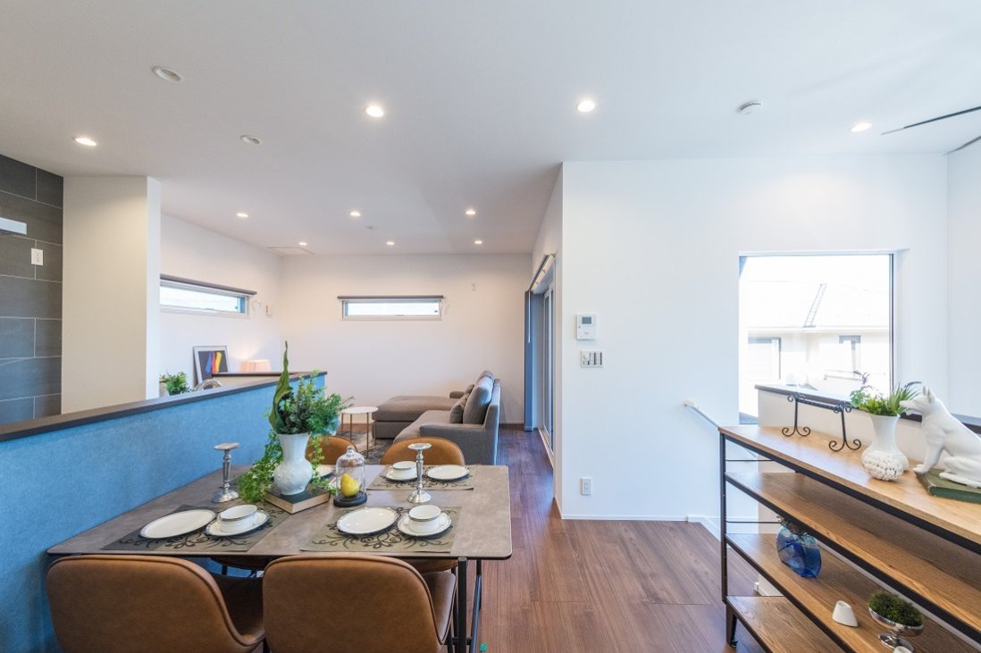 吹抜けに設けた大きな窓やバルコニーを望む窓から沢山の陽が注ぐ