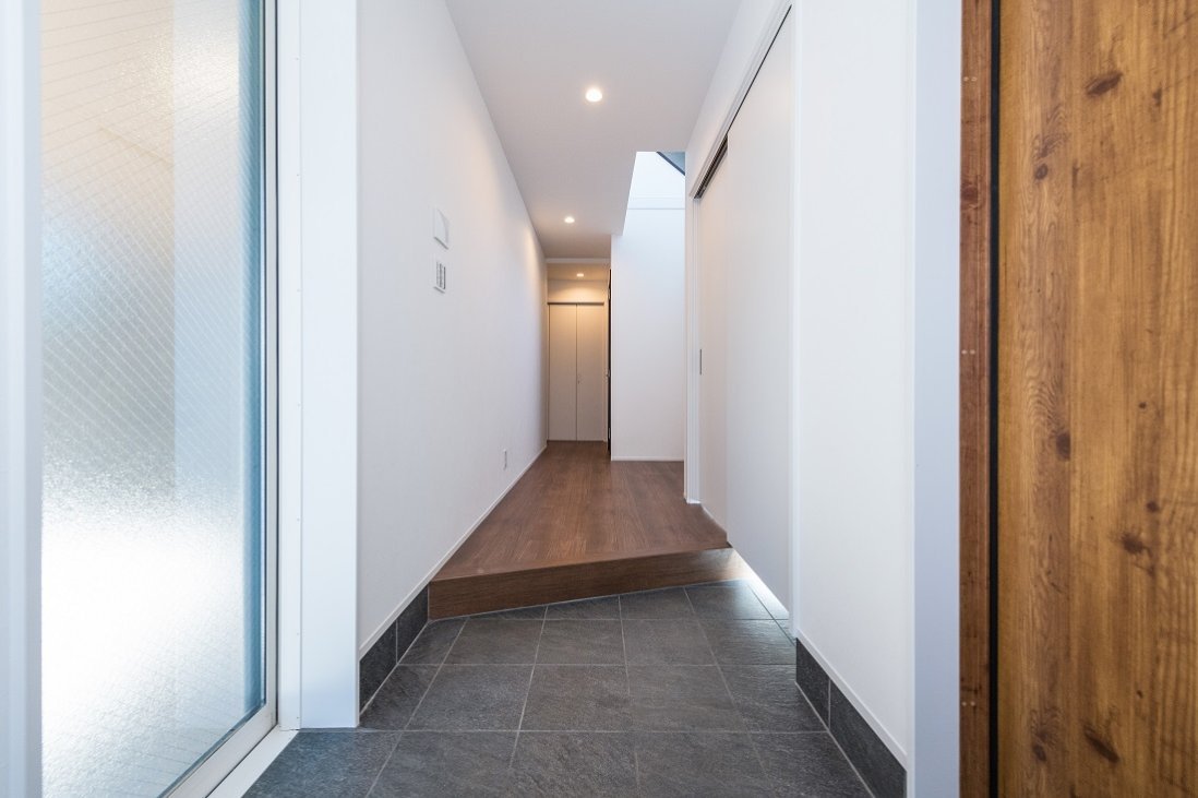 玄関ドアの対面にはガレージからもお家に入れるガラス戸がある