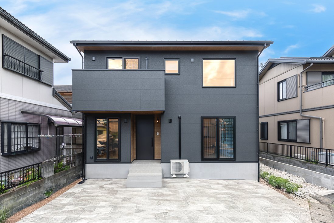 リシン調の黒いモルタル壁のデザインに黒のサッシがクールな印象