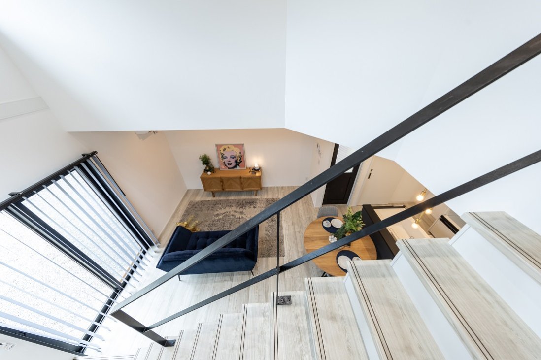 吹抜け階段をアイアンブラックの手摺りにすることで生まれる開放感