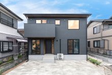 リシン調の黒いモルタル壁のデザインに黒のサッシがクールな印象