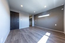 床と壁の印象を他の居室とは違うダークカラーで演出した主寝室