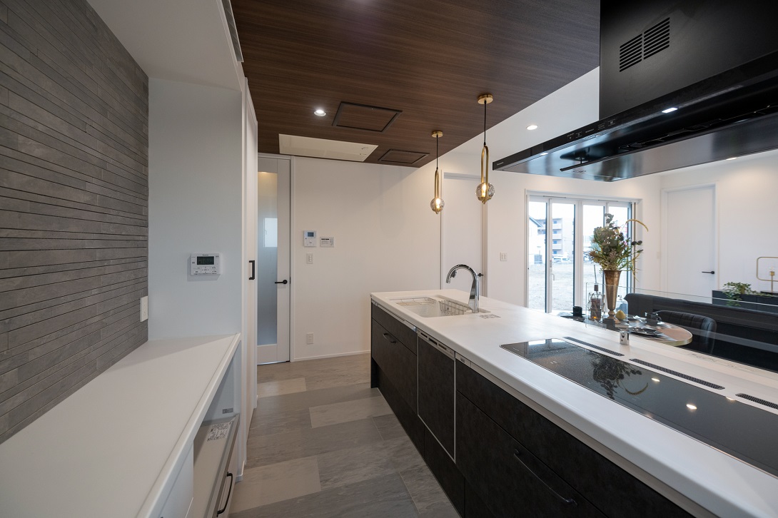  重厚感のあるタイルをアクセントにしたキッチンはスタイリッシュな空間を演出する