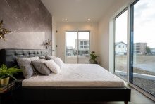  寝室はシックな雰囲気にし、大きなテラス窓で明るくスッキリとした印象に